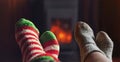 Two pair feet legs in winter wool socks at fireplace background. Couple family sitting at home on winter or autumn Royalty Free Stock Photo