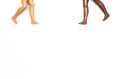 Two pair of toy dolls legs going to each other on white background. Different skin tones and races. Stop racism.