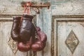 Two pair of vintage boxing gloves hanging on a weathered ancient