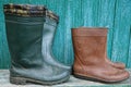 Two pairs of dirty rubber boots on a green wall Royalty Free Stock Photo