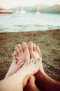 Two pairs of feet, male and female crossed on sea Royalty Free Stock Photo