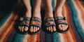 Two pairs of feet, one wearing rainbow-striped socks and the other in multicolored sandals, standing side by side on a Royalty Free Stock Photo