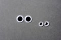 Two pairs of looking googly eyes on grey background Royalty Free Stock Photo