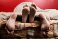 Two pairs of male and female feet seen from under the blanket. sleep together, lovers having sex Royalty Free Stock Photo