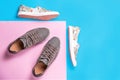 Two pairs of a new slip-ons made of floral pattern canvas and sneakers on a pink-blue background. Flat lay. Copy space Royalty Free Stock Photo