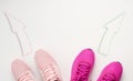 Two pairs of pink textile sneakers are directed in opposite directions. Quarrel and difference of opinion concept, different life