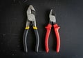 Two pairs of pliers are displayed on a black surface. The left pair is a combination of pliers, Royalty Free Stock Photo