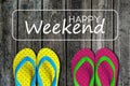 Two pairs sandals with text happy weekend on wooden background Royalty Free Stock Photo