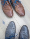 Two pairs of shoes toe to toe on a wooden floor Royalty Free Stock Photo