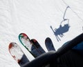 Two pairs of skis, people on the lift climb the snow-covered mountain slope