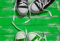 Two pairs of sneakers youth with untied laces on the green surface Royalty Free Stock Photo