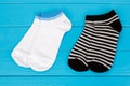 Two pairs of socks laying on a blue wooden background.