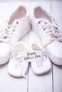 Two pairs of sports shoes on a white wooden background. The shoes of father and son or daughter. Fathers day concept Royalty Free Stock Photo