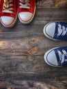 Two pairs of textile shoe on a gray wooden surface