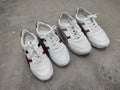 Two pairs of white sneakers on a cement floor Royalty Free Stock Photo