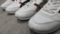 Two pairs of white sneakers on a cement floor Royalty Free Stock Photo