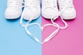 Two pairs of white sneakers and heart symbol made of the laces Royalty Free Stock Photo