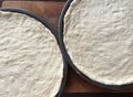 Two pans of raw pizza dough