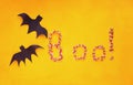 Two Paper Bats and Candy Over an Orange Background