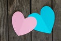 Two paper blue and pink hearts cut out lies on a wooden background close-up Royalty Free Stock Photo