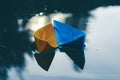 two paper boats, yellow and blue, float in the pond. The light shimmers beautifully in the water. The boat is floating Royalty Free Stock Photo