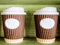 Two paper coffee cups with green background Royalty Free Stock Photo