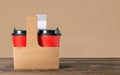 Two paper coffee cups to go in card-box basket with copy space. Royalty Free Stock Photo