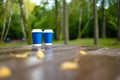 Two paper coffee cups on wooden table in outdoors cafe. Exploring nature on rainy autumn day Royalty Free Stock Photo