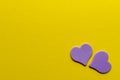 Two paper purple hearts on yellow background