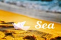 Two paper white ships on the sand near the sea.The inscription of the sea against the background of sand and sea Royalty Free Stock Photo