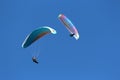 Two paragliders in blue sky