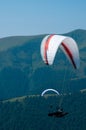 Two paragliders fly over a mountain valley on a sunny summer day. Royalty Free Stock Photo