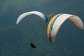 Two paragliders fly over a mountain valley on a sunny summer day. Royalty Free Stock Photo