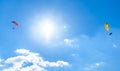 Two paragliders flying against the blue sky with white clouds. Royalty Free Stock Photo