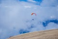 Two paragliders flying in the clouds near lake Garda