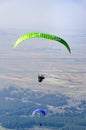 Two paragliders flying over the mountains during a paragliding competition Royalty Free Stock Photo