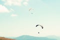 Two paragliders in sky with hills in background Royalty Free Stock Photo