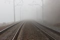 Two parallel tracks of the railway, going into the distance into fog and suspense