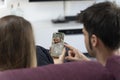 Two parents sitting on the sofa and monitoring their baby on the phone