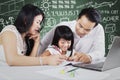 Two parents teach their child in the class Royalty Free Stock Photo