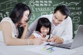 Two parents and their child doing homework Royalty Free Stock Photo