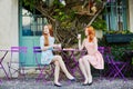 Two Parisian women drinking coffee together in cafe