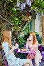 Two Parisian women drinking coffee together in cafe