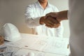 Two partnership engineering man with construction worker greeting shaking hand a foreman at renovating apartment Royalty Free Stock Photo