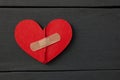 Two parts of red broken wooden heart taped by a patch. Royalty Free Stock Photo