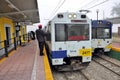 Two passenger trains stand at the station.