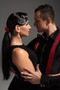 Two passionate dancers performing tango face to face