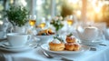 Two pastries with whipped cream on a white plate on a table set for afternoon tea Royalty Free Stock Photo