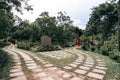 Pathways and an old memorial statue in the middle of them in Angkor Botanical Garden, Cambodia Royalty Free Stock Photo