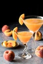 Two peach Bellinis garnished with peach slices, against a dark background. Royalty Free Stock Photo